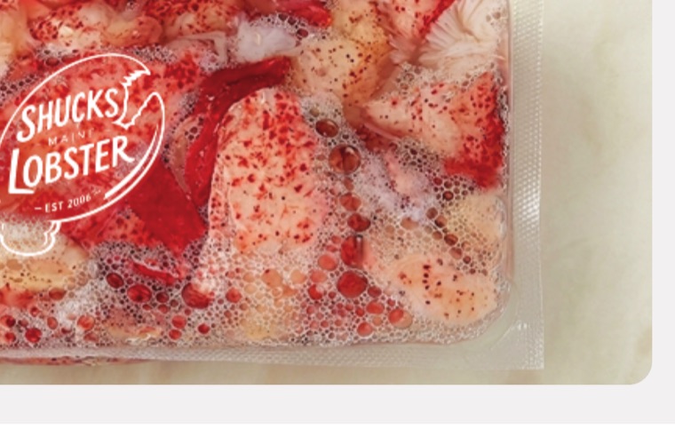 Vacuum-sealed retail pack of Shucks raw HPP lobster meat with the Shucks Maine Lobster label